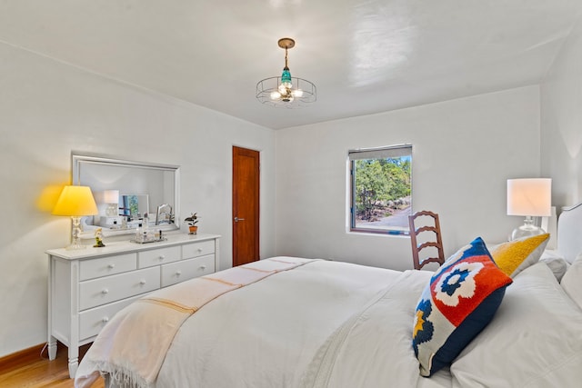 bedroom featuring a notable chandelier and light hardwood / wood-style floors