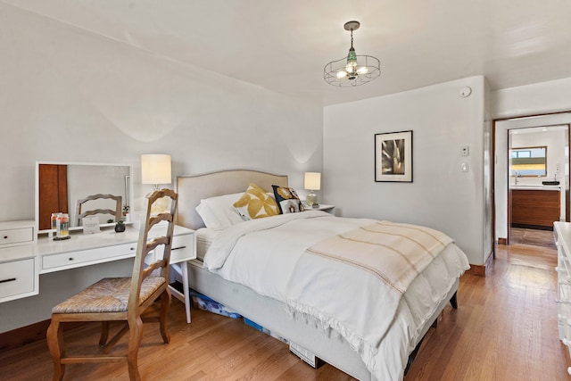 bedroom featuring light hardwood / wood-style floors and a notable chandelier