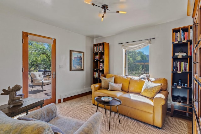 living area with a baseboard radiator, baseboards, and light wood finished floors