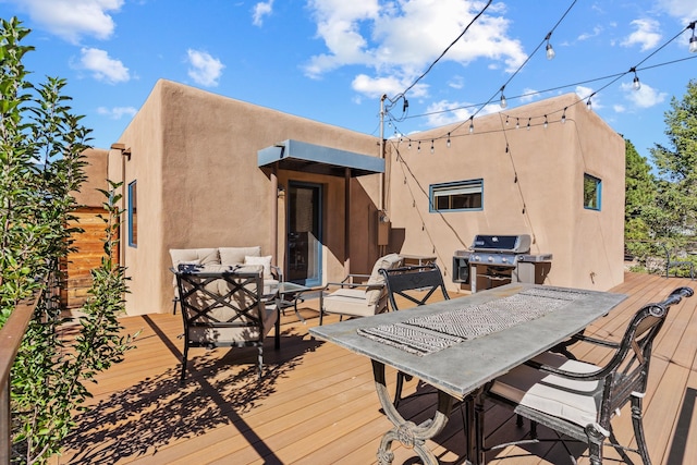 wooden deck with outdoor dining area and grilling area