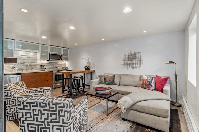 living area with recessed lighting, light wood-style flooring, and baseboards