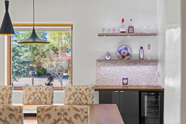 dining space featuring a wealth of natural light, wine cooler, and a bar