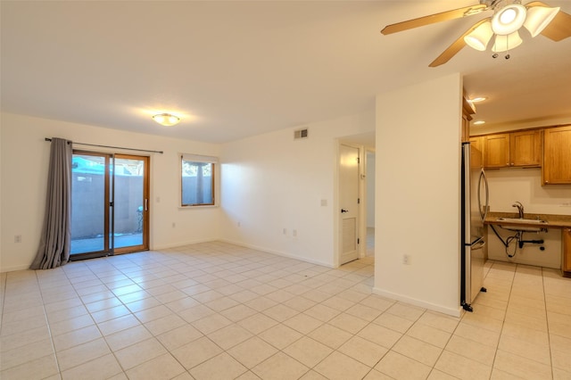 tiled spare room featuring ceiling fan and sink