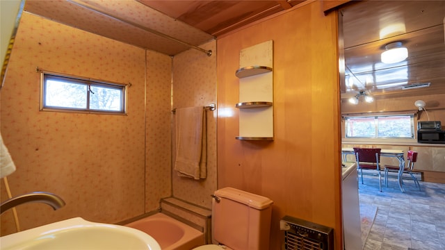 bathroom featuring tub / shower combination, ceiling fan, and a healthy amount of sunlight