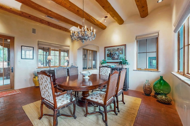 dining area with beam ceiling and a notable chandelier