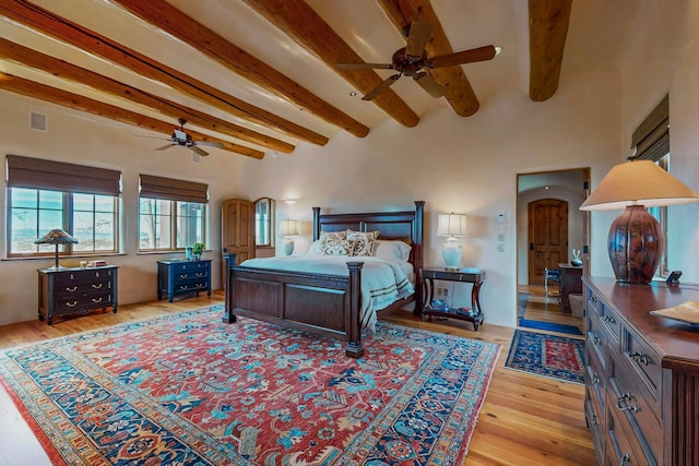 bedroom with beam ceiling, ceiling fan, and light hardwood / wood-style flooring