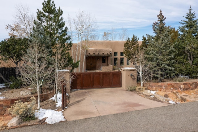 pueblo revival-style home featuring fence