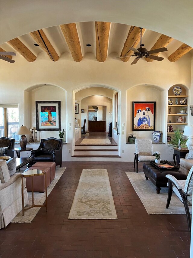 living room with a mountain view, a high ceiling, ceiling fan, and a healthy amount of sunlight