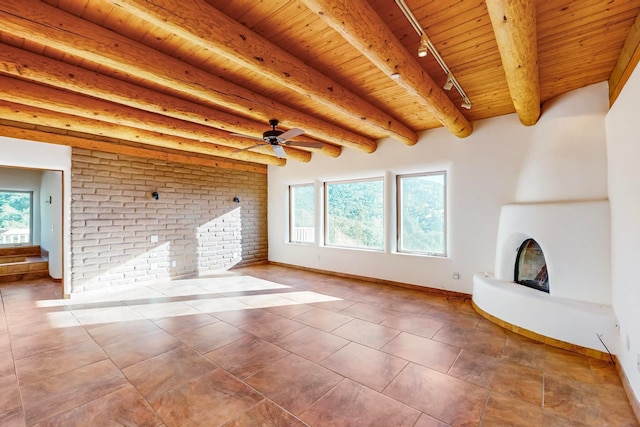 unfurnished living room with tile patterned flooring, beam ceiling, wood ceiling, and rail lighting