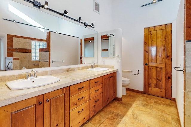 bathroom featuring vanity, toilet, and walk in shower