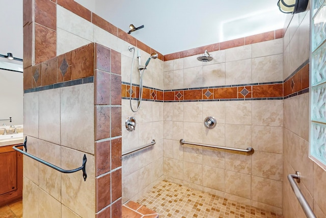 bathroom with tile patterned floors, vanity, and a tile shower