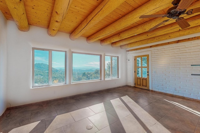 unfurnished sunroom with a mountain view, beam ceiling, and wooden ceiling