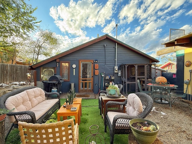 back of house with outdoor lounge area, a sunroom, and a patio