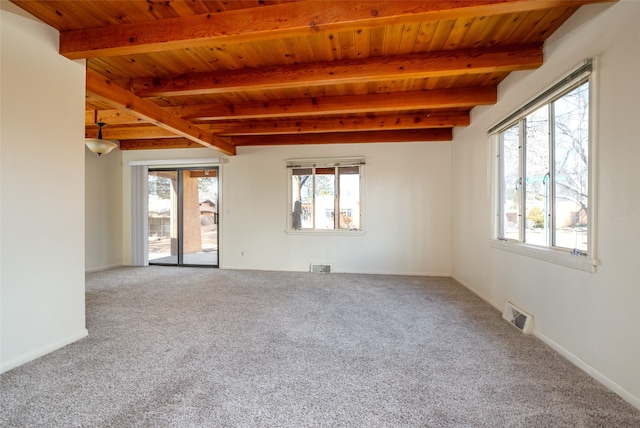 empty room featuring beam ceiling, carpet floors, and wood ceiling