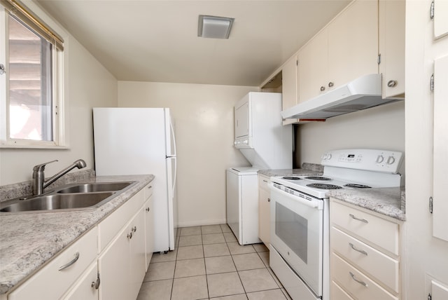 kitchen featuring white appliances, stacked washer and clothes dryer, white cabinets, sink, and light tile patterned floors