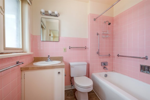 full bathroom with tiled shower / bath, vanity, toilet, and tile walls