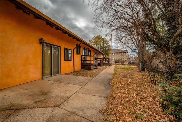 view of home's exterior featuring a deck and a patio