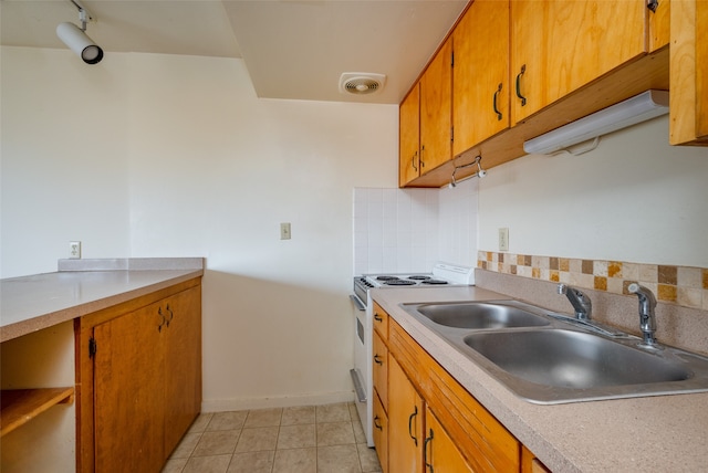 kitchen with sink, electric range, decorative backsplash, and light tile patterned floors