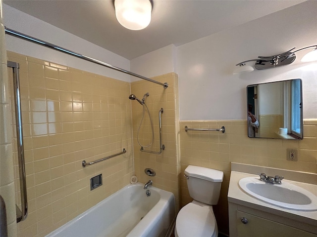 full bathroom with tile walls, toilet, vanity, and tiled shower / bath combo