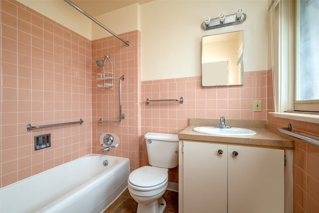 full bathroom with vanity, tile walls, toilet, and tiled shower / bath