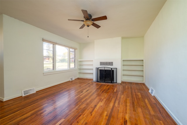 unfurnished living room with ceiling fan and dark wood-type flooring