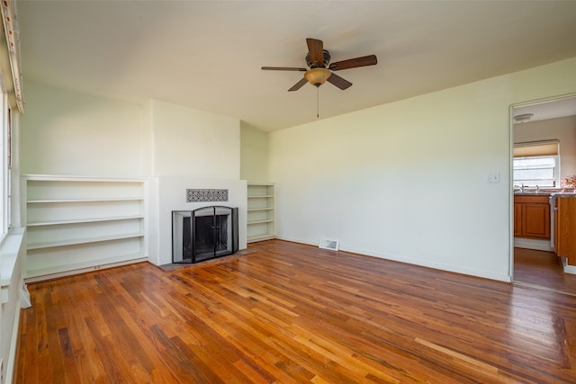 unfurnished living room featuring ceiling fan and dark hardwood / wood-style floors