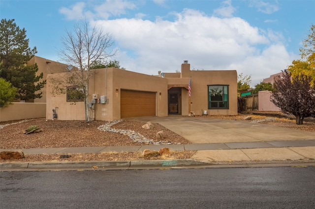 pueblo-style house featuring a garage