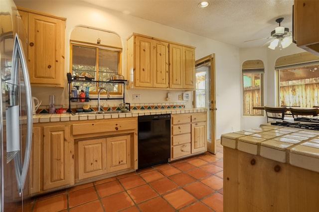 kitchen with stainless steel fridge, ceiling fan, sink, dishwasher, and tile counters