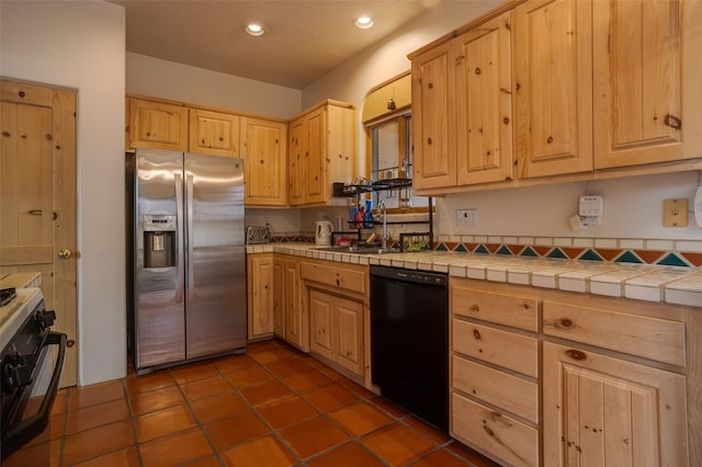 kitchen featuring light brown cabinets, sink, tile countertops, and black appliances