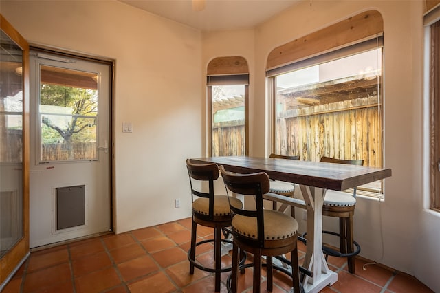 tiled dining space with ceiling fan