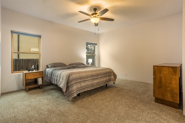 bedroom with carpet flooring, ceiling fan, and a textured ceiling