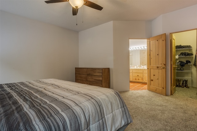 carpeted bedroom with connected bathroom, a closet, a spacious closet, and ceiling fan