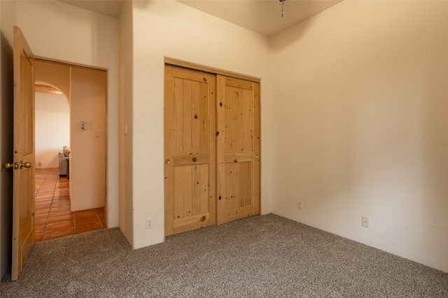 unfurnished bedroom with carpet floors and a closet