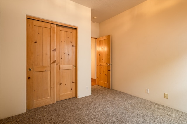 unfurnished bedroom featuring carpet flooring and a closet