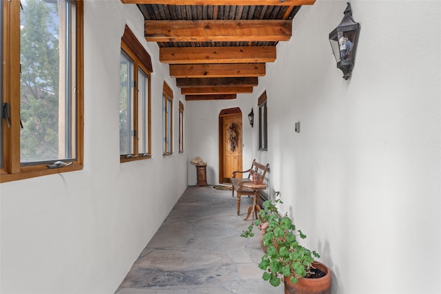 hall featuring beamed ceiling and wooden ceiling