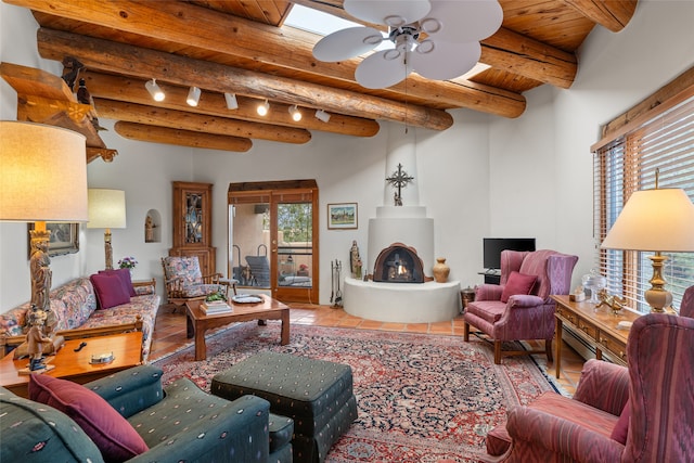 tiled living room with ceiling fan, beam ceiling, wood ceiling, and rail lighting