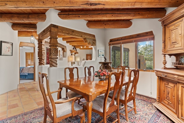 dining room featuring beam ceiling, light tile patterned floors, and wooden ceiling