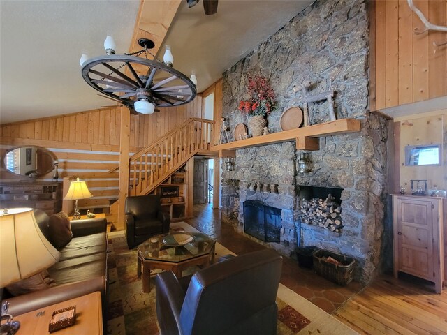 living room with ceiling fan, wooden walls, high vaulted ceiling, a fireplace, and hardwood / wood-style floors