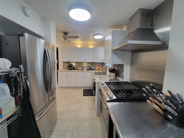 kitchen with backsplash, white cabinets, wall chimney range hood, sink, and appliances with stainless steel finishes