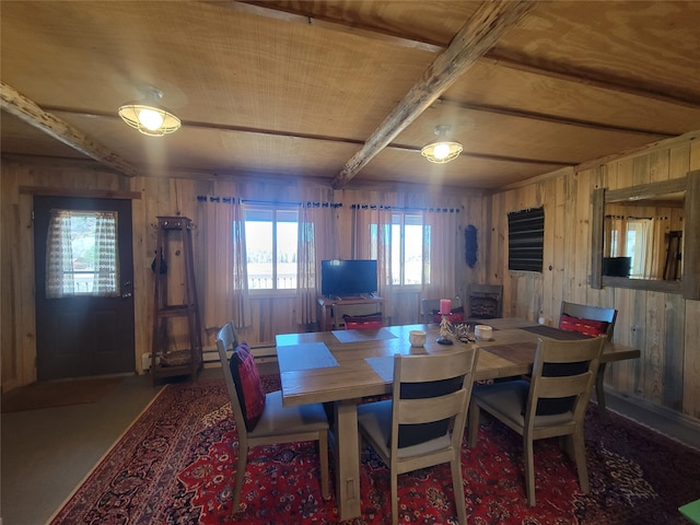 dining area featuring beam ceiling and wood walls