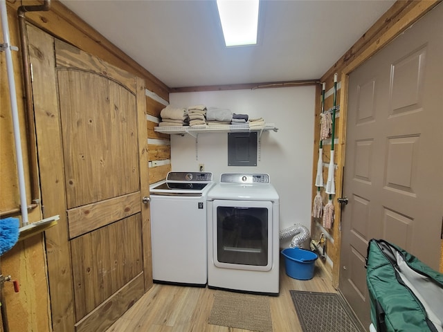 clothes washing area with light wood-type flooring and washing machine and dryer