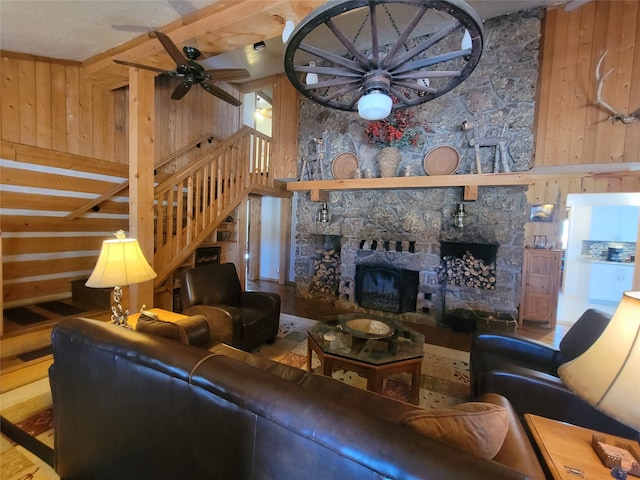 living room with a stone fireplace, wooden walls, hardwood / wood-style floors, and ceiling fan