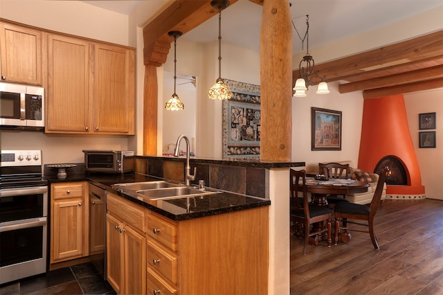 kitchen with appliances with stainless steel finishes, dark hardwood / wood-style flooring, sink, beam ceiling, and hanging light fixtures