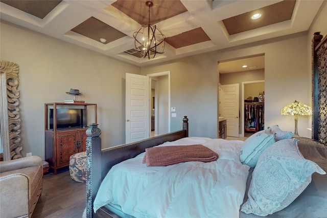 bedroom with coffered ceiling, an inviting chandelier, a spacious closet, dark hardwood / wood-style floors, and a closet