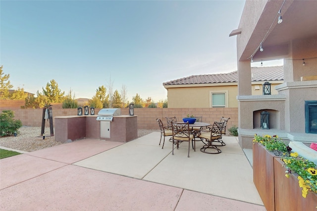 view of patio with grilling area, an outdoor kitchen, and an outdoor fireplace