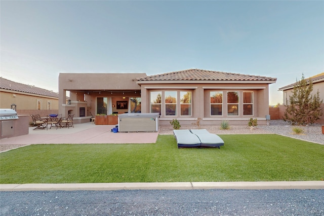 back of house featuring a fireplace, a yard, and a patio