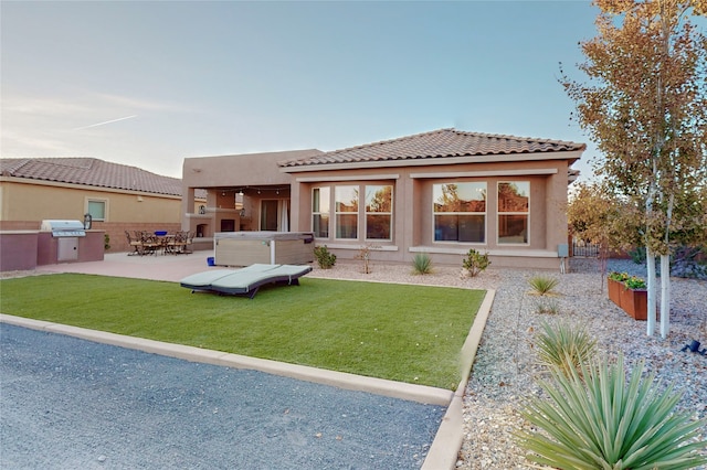 back of property featuring a patio area, a yard, area for grilling, and a hot tub