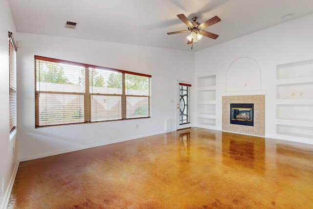 unfurnished living room featuring built in shelves, ceiling fan, and a fireplace