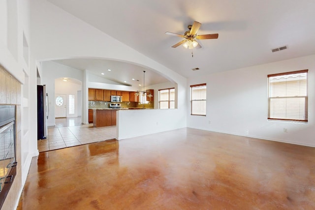 unfurnished living room featuring ceiling fan, plenty of natural light, and lofted ceiling