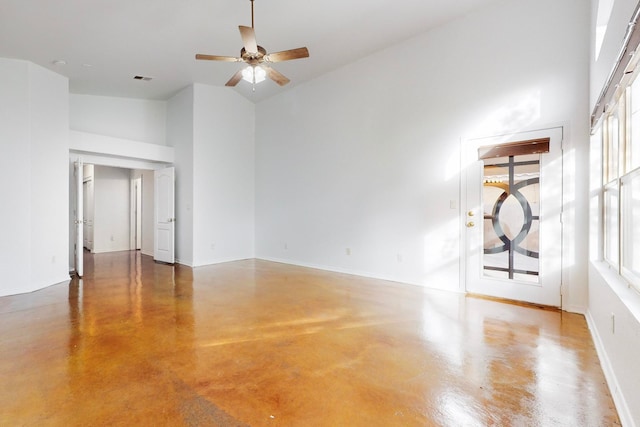 unfurnished living room featuring ceiling fan, concrete flooring, and high vaulted ceiling